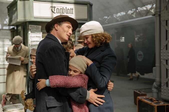 Mutter, Vater, Max und Anna umarmen sich am Bahnhof.